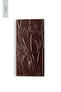 A Cardamon Honey Caramel Chocolate Bar that is pressed with a pattern of trillium flowers.