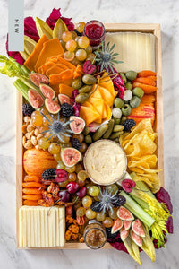 The NEW Après Ski Cheese Board filled with Vermont and alpine cheese, pickles, fruits, vegetables, and nuts.