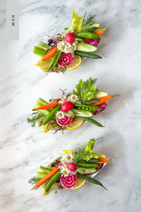 A trio of fresh vegetable single serve crudite grazing boats, filled with the season's freshest vegetables paired with a scoop of lemon dill hummus, accented with fresh flowers and herbs.