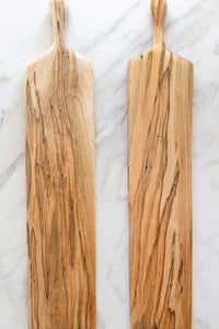 A pair of Ambrosia Maple bread boards on a marble counter.