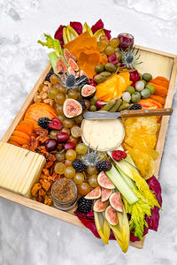 The Après Ski Cheese Board filled with Vermont and alpine cheese, pickles, fruits, vegetables, served outside in the snow.