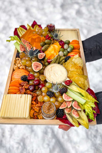 The Après Ski Cheese Board filled with Vermont and alpine cheese, pickles, fruits, vegetables, served outside in the snow.