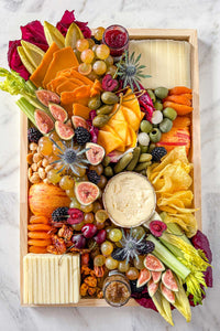 The Après Ski Cheese Board filled with Vermont and alpine cheese, pickles, fruits, vegetables, and nuts.