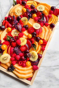 A fresh seasonal fruit platter available for delivery in Vermont, abundant and overflowing with fresh melons, stone fruit, raspberries, cherries, kiwi, and seasonal fruit favorite.