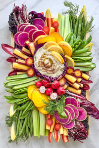 A fresh vegetable crudité platter spread with a rainbow of vegetables arranged in an artful and colorful spread. 