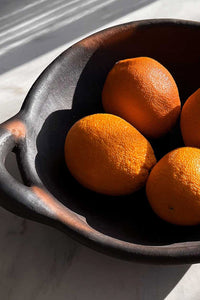 The Burnt Terracotta Serving Bowl - A Handmade Rustic Terracotta Serving Bowl With Handles, shown here filled with oranges in late afternoon light